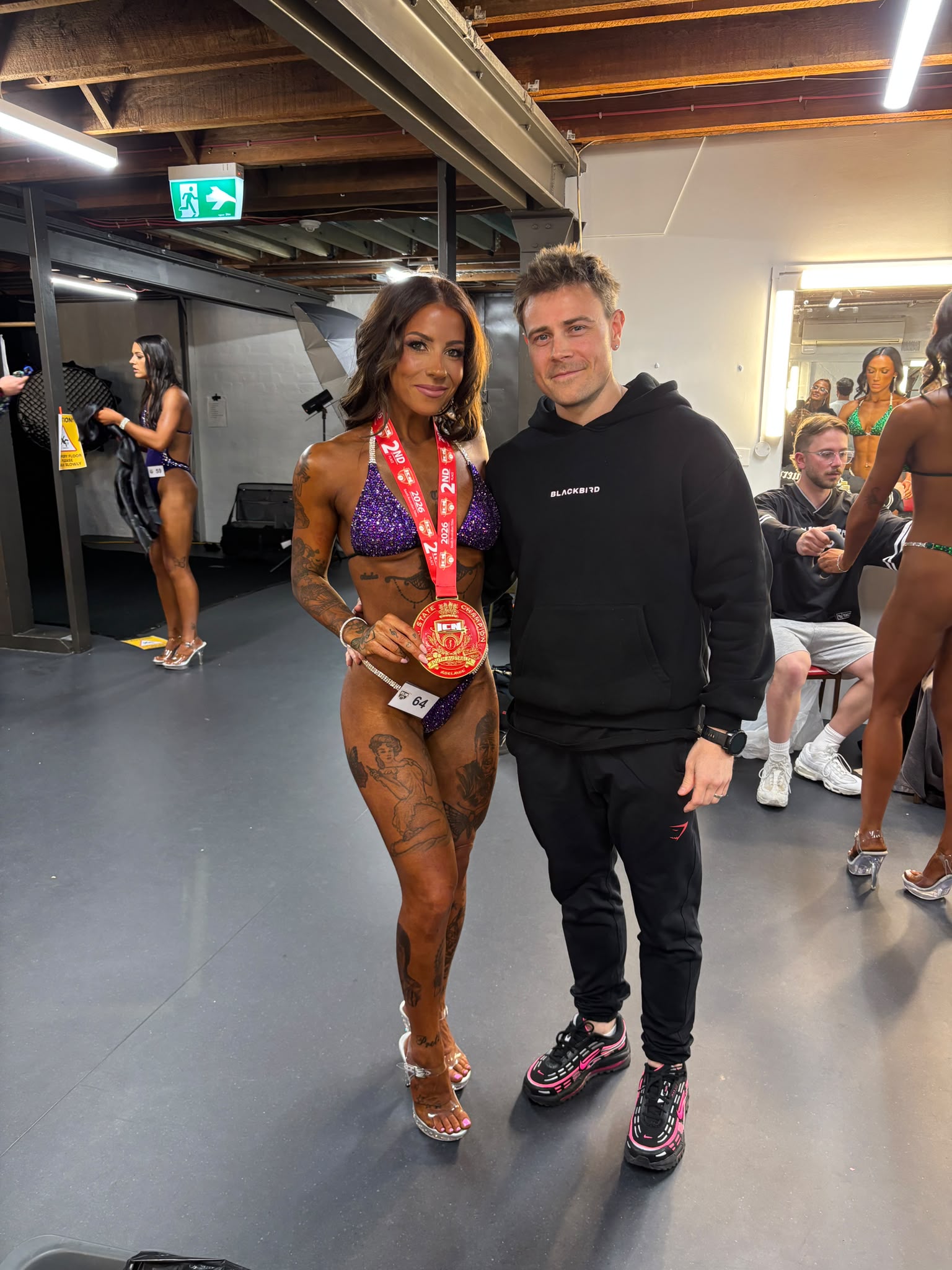 Phil Janicki backstage with client Tenille, who is wearing her competition medal